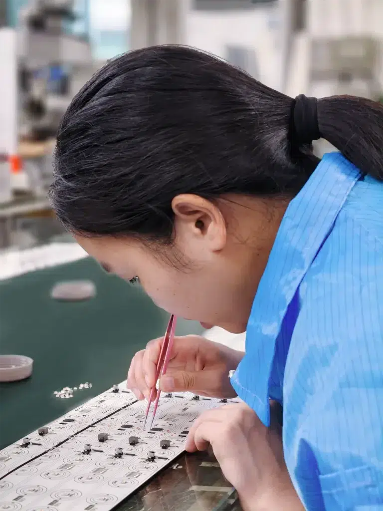 worker manually placing LED light board during assembly