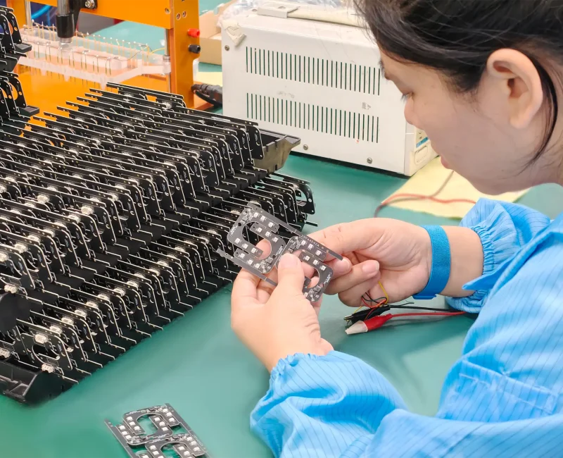 Close-up of worker lighting up LED pcba to test illumination and uniformity